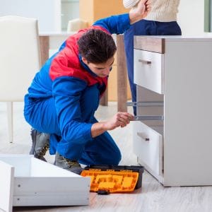 Man die mee helpt met afval verminderen door meubels te repareren.